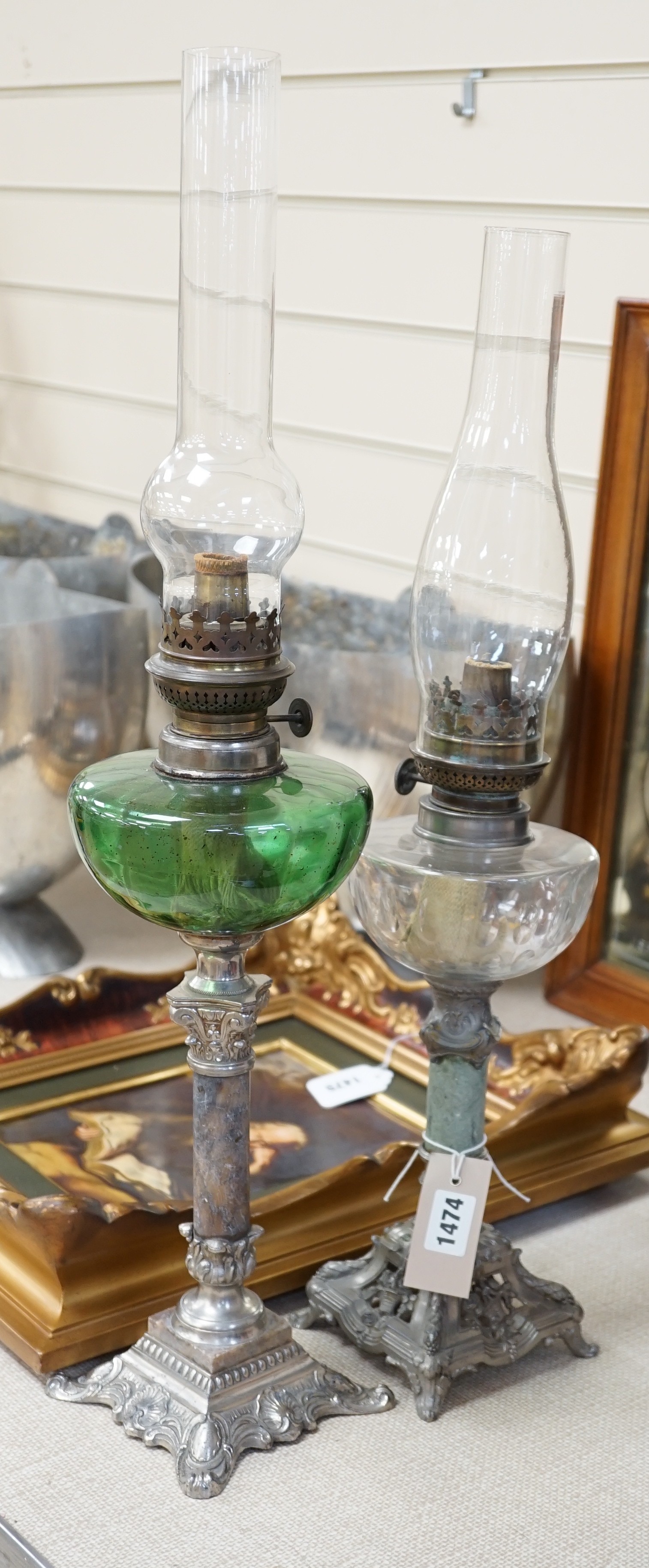 Two metal oil lamps and glass funnels, tallest 66cms high